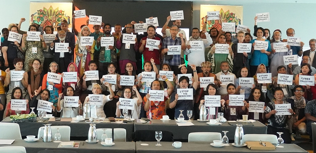 PANAP delegates at a network gathering holding placards in solidarity with Palestine