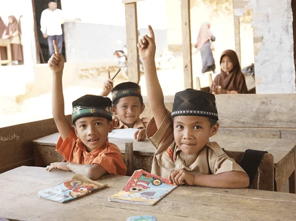 Schoolchildren beside a field being sprayed