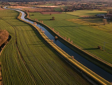An aerial view of a river winding between cultivated fields