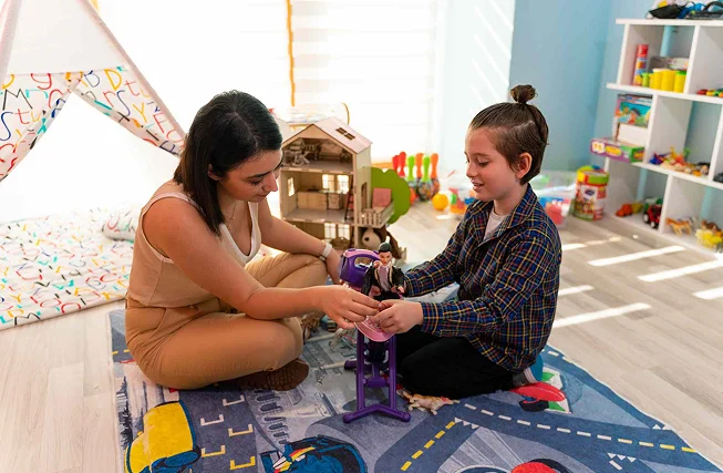 Teachers working one to one with young children in a classroom